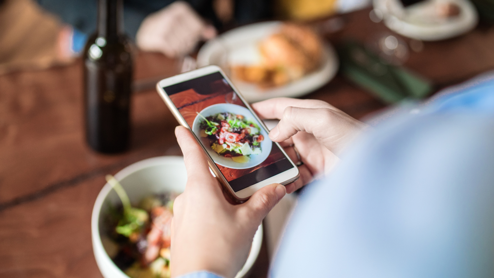 Person taking a photo of their salad using an iPhone.