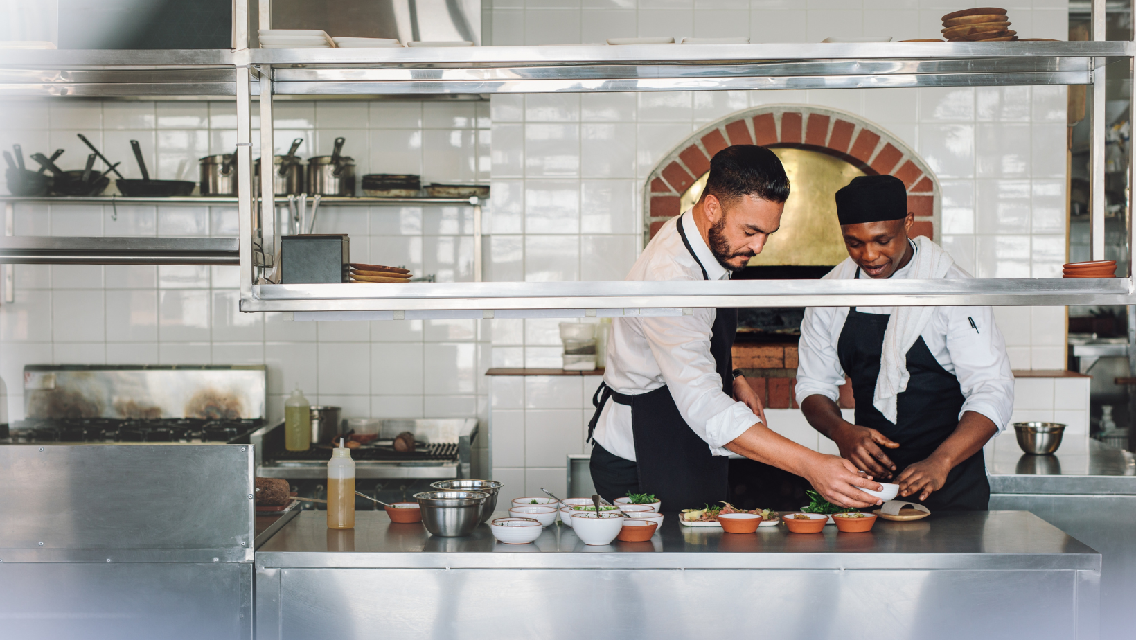 A chef training his colleague in the kitchen during off-peak service hours.